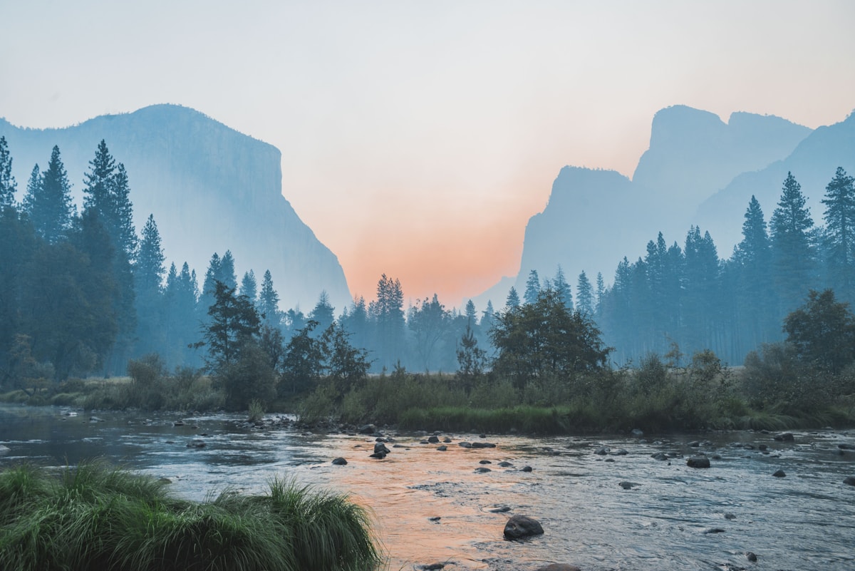 A quiet river winding through a mountain valley at dusk
